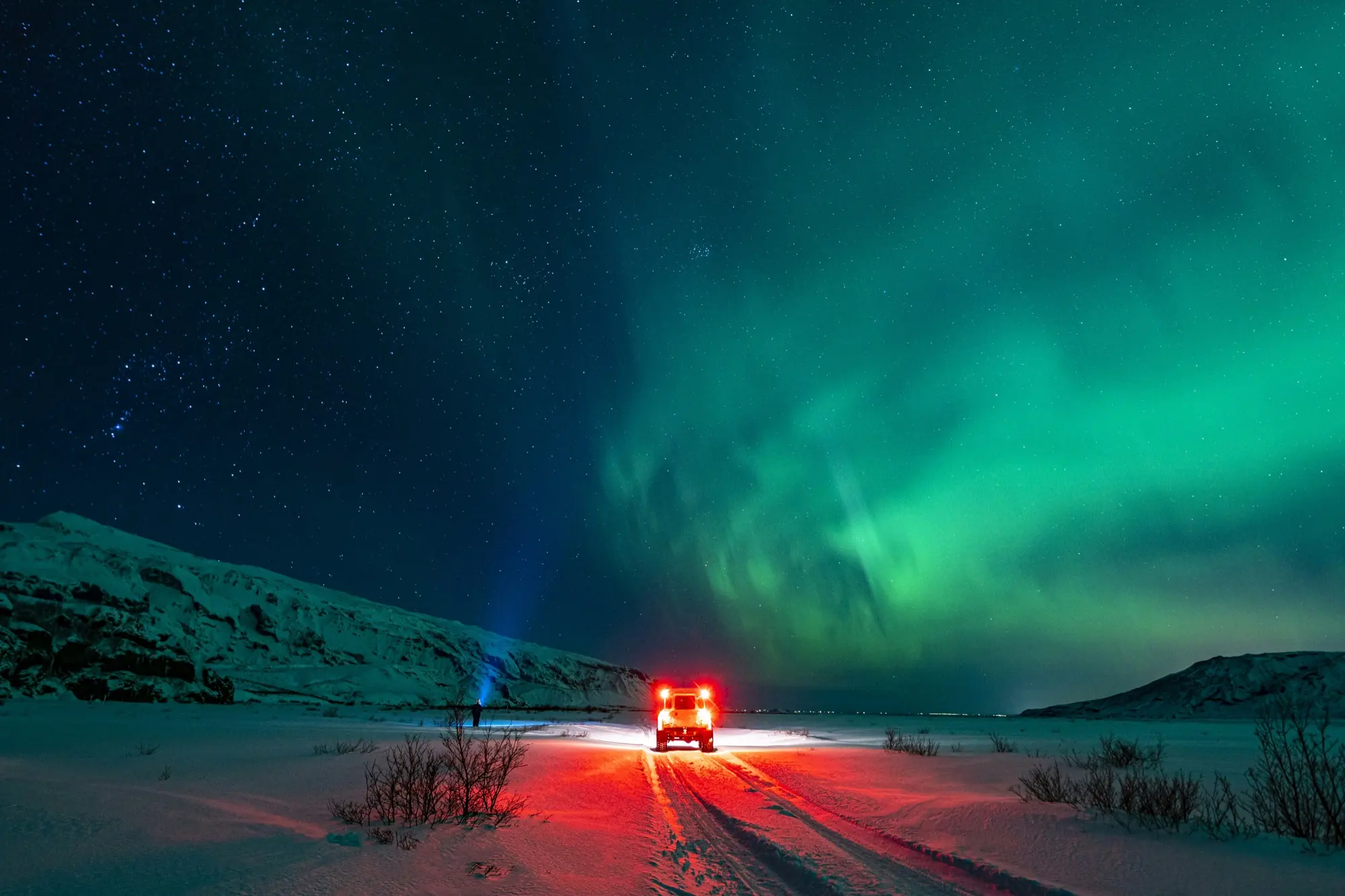 A super jeep tour stopped under the aurora on an Icelandic highland road
