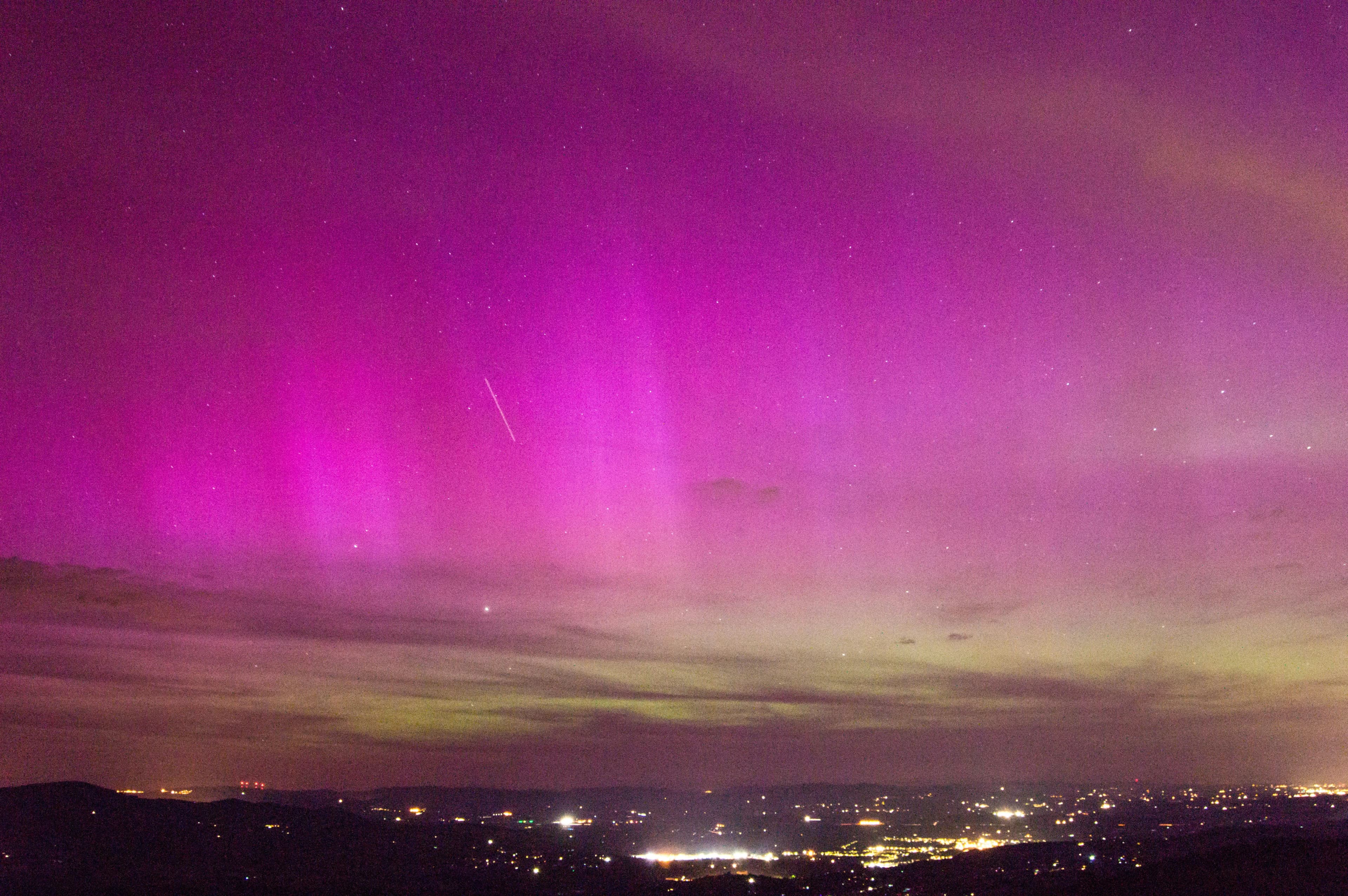 Camera on tripod photographing aurora borealis
