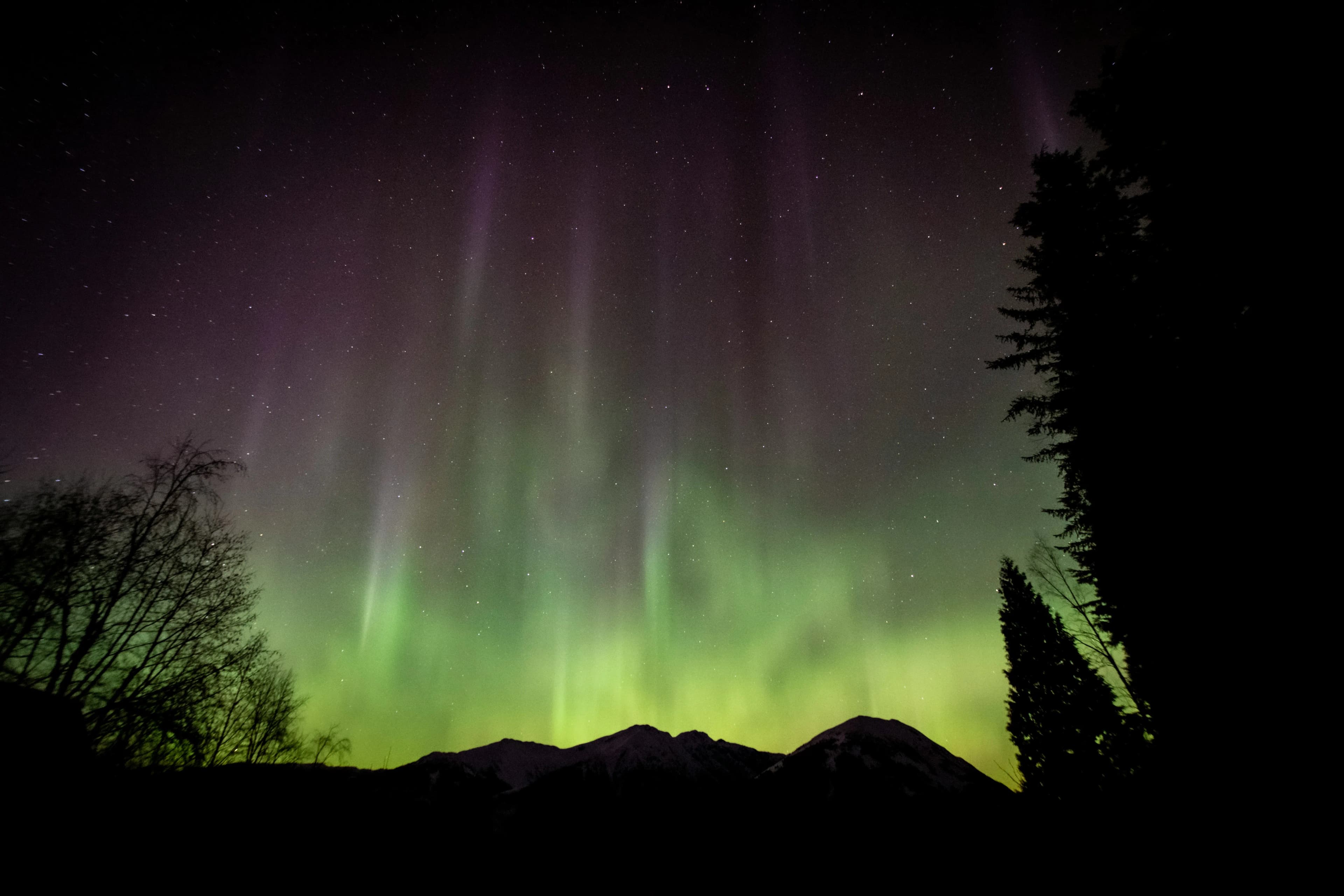 Aurora visible through a gap in clouds